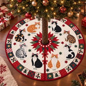 May include: A round, quilted Christmas tree skirt featuring a central red and green star pattern surrounded by eight illustrated cats named Oliver, Luna, Milo, Chloe, Leo, Bella, Lucy, and Daisy. The border has red, green, and white holiday motifs.