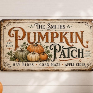 Puede incluir: Un letrero rectangular de metal con fondo crema desgastado que presenta el texto The Smiths Pumpkin Patch, Est. 1992, Hay Rides, Corn Maze, Apple Cider y Grown with love, picked with care, junto a ilustraciones de tres calabazas.