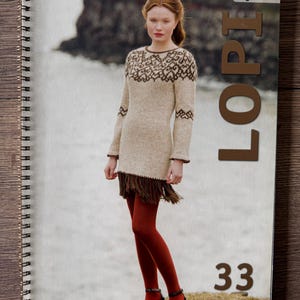 Può includere: Copertina di libro a spirale con una donna che indossa un abito a maglia beige e marrone fantasia. La parola "LOPI" è stampata verticalmente in grandi lettere marroni. Il numero "33" è in basso. La parola "English" è in alto a destra.