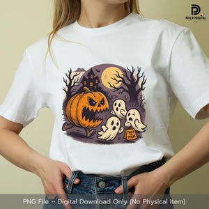 Puede incluir: Camiseta blanca con un diseño de Halloween. El diseño incluye una calabaza naranja, fantasmas, una casa embrujada y una luna llena. Los fantasmas llevan una bolsa con la frase "Trick or Treat".