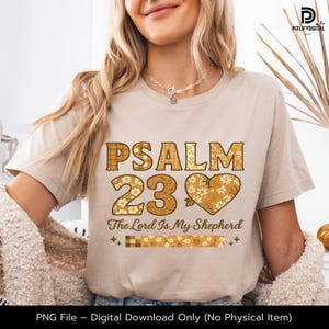 May include: Beige t-shirt with the text "PSALM 23 The Lord Is My Shepherd" in a decorative design. The text is in shades of brown and gold, with a heart-shaped floral design. The shirt is a digital download.