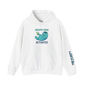 May include: White hoodie featuring a cartoon manatee in sunglasses with a drink, and the text "MANATEE MODE ACTIVATED". The right sleeve displays "THE FLOATY".