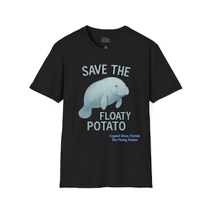 Puede incluir: Camiseta negra con una ilustración azul claro de un manatí y el texto "SAVE THE FLOATY POTATO". Debajo está el texto "Crystal River, Florida The Floaty Potato".