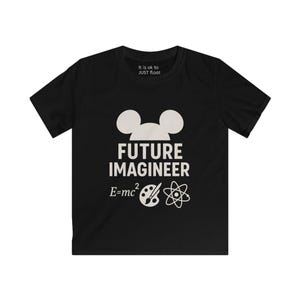 May include: Black t-shirt with a white graphic featuring mouse ears, the words "FUTURE IMAGINEER", and the equation E=mc². Additional text at the top reads "It is ok to JUST float". The design includes a paintbrush, a palette, and an atom symbol.