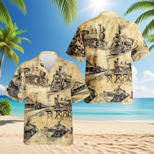 May include: Short-sleeved button-down shirt featuring a vintage train design. The shirt has a beige background with black and brown illustrations of steam locomotives and railroad tracks. The shirt is displayed on a beach setting.