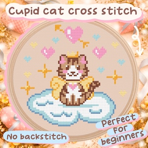 Peut inclure: Un cercle de broderie au point de croix avec un motif de chat Cupidon. Le chat, avec une couronne et des ailes, est sur un nuage. Le motif comprend des cœurs, des étoiles et le texte "Cupid cat cross stitch" et "No backstitch".