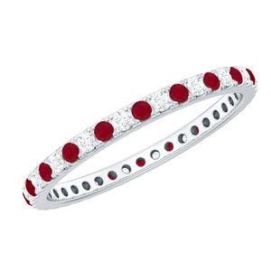 Könnte beinhalten: Ein silberner Eternity-Ring mit abwechselnd runden, leuchtend roten und klaren, funkelnden weißen Edelsteinen. Der Ring ist mit mehreren Edelsteinen um das gesamte Band besetzt, wodurch ein durchgehendes Muster entsteht. Der Ring wird vor weißem Hintergrund gezeigt.