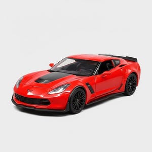 May include: A red sports car model with black wheels and a black hood. The car has a sleek design with a spoiler and is set against a white background. The model car is a collectible item.