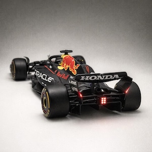 May include: A black and red Formula 1 race car model with the Red Bull logo. The car has the Oracle and Honda logos. The tires are black with yellow rims. The rear lights are illuminated.