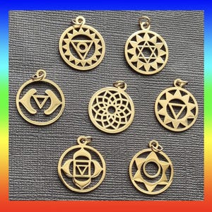 May include: Seven gold-colored pendant charms with various geometric and symbolic designs. Each charm is circular with a small loop at the top for a chain. The designs include triangles, stars, and floral patterns, suitable for jewelry or craft projects.