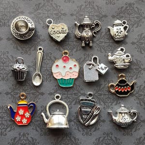 May include: Assortment of silver and enamel charms with tea party themes. Charms include a teapot, teacup, cupcake, cookie, spoon, tea bag, and more.