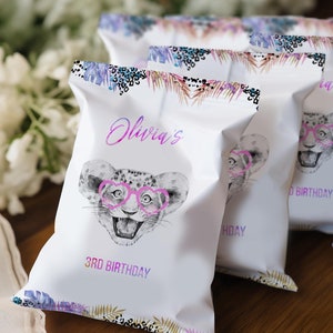 Può includere: Buste regalo bianche con un design ad acquerello rosa e viola che presenta un ghepardo dei cartoni animati con occhiali a forma di cuore rosa. Le buste recitano "Olivia's 3rd Birthday" in testo viola.