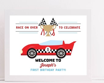 Peut inclure: Impression encadrée avec une illustration de voiture de course rouge et des détails à carreaux noirs et blancs. L'impression comprend le texte « Race on over to celebrate » et « Welcome to Joseph's First Birthday Party ! » Un trophée doré et des drapeaux à damier sont également inclus.