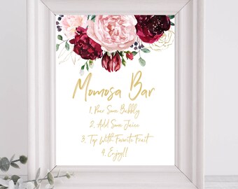 May include: A printable sign with a floral design in shades of pink and burgundy with gold accents. The sign says "Momosa Bar" and includes instructions for making mimosas: "1. Pour some bubbly, 2. Add some juice, 3. Top with favorite fruit, 4. Enjoy!!"
