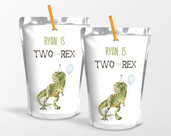 May include: Two white juice boxes with green dinosaur illustrations and the text "Ryan is Two Rex" on each. The juice boxes have orange straws inserted in the top.