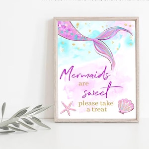 May include: A printable sign with a watercolor background featuring a mermaid tail with pink and purple scales. The sign says "Mermaids are sweet, please take a treat".