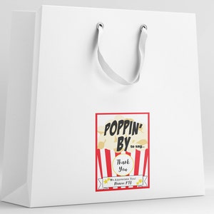 Może przedstawiać: Biała papierowa torba prezentowa z wzorem czerwono-białej, pasiastych pudełek na popcorn. Tekst na torbie brzmi "Poppin' By to say... Thank You. We Appreciate You!  [Name] PTO".