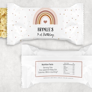 K&ouml;nnte beinhalten: Ein wei&szlig;er Snackbeutel mit einem Regenbogen-Design und goldenen Konfetti. Auf dem Beutel steht "BRYNLEE'S 3rd Birthday". Der Beutel enth&auml;lt einen wei&szlig;en Reis-Crispies-Snack.