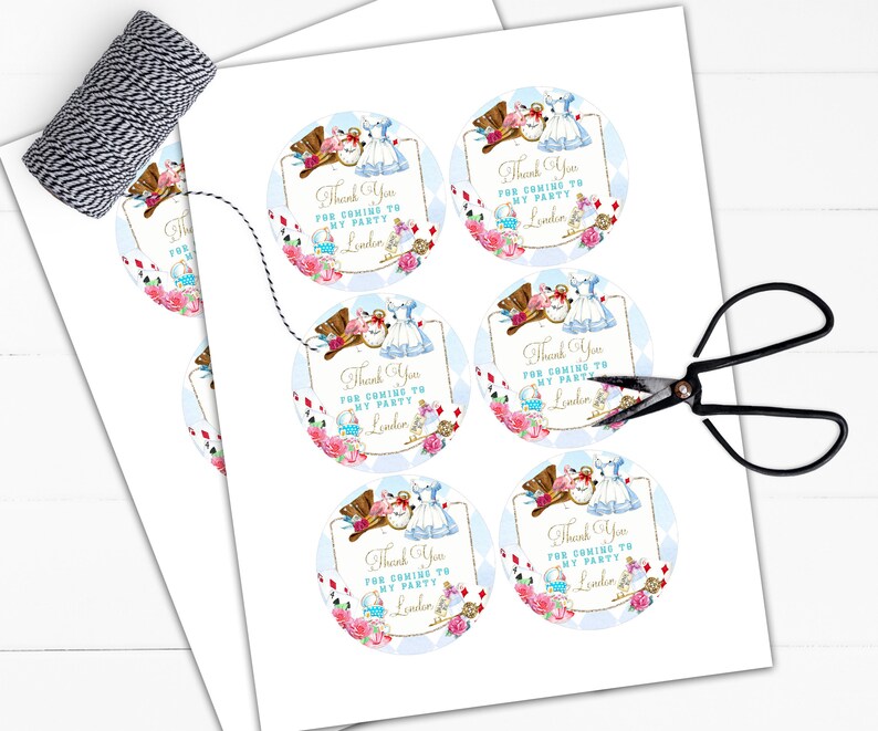May include: Six round thank you stickers with a whimsical Alice in Wonderland theme. The stickers feature illustrations of Alice and the Mad Hatter, with a blue and white background and gold accents. The text on the stickers reads "Thank You for coming to my party, [Name]"