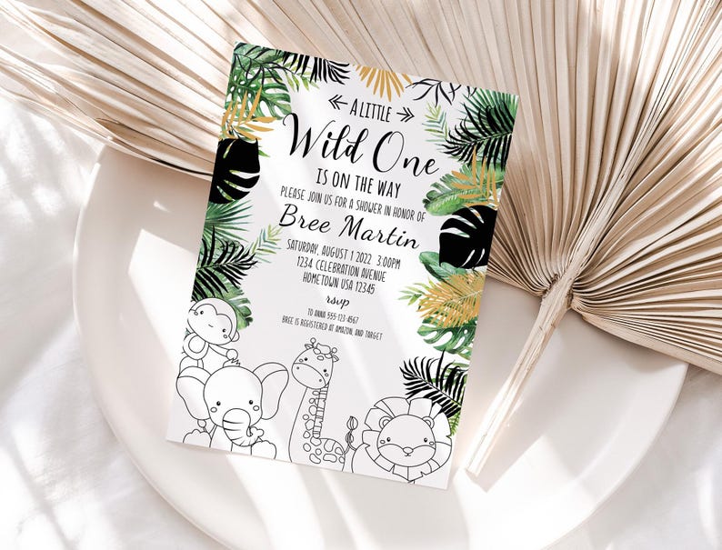 May include: A white invitation with green and gold tropical leaves and black silhouettes of leaves. The text reads "A Little Wild One is on the Way" and includes the name "Bree Martin" and details for a baby shower. The invitation features black and white line drawings of a monkey, elephant, giraffe, and lion.