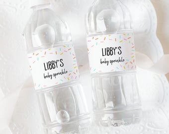 May include: Two clear plastic water bottles with colorful sprinkle-themed labels that say "Libby's baby sprinkle".