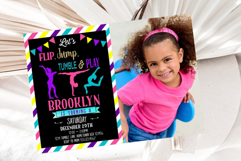 May include: A colorful invitation for a gymnastics-themed birthday party. The invitation features a black chalkboard background with the text "Let's FLIP, Jump, TUMBLE & PLAY" in colorful letters. The invitation also includes a photo of a young girl with curly hair wearing a pink shirt and a pink headband. The text "BROOKLYN IS TURNING 8" is written in pink and white letters. The invitation includes the date, time, and location of the party.