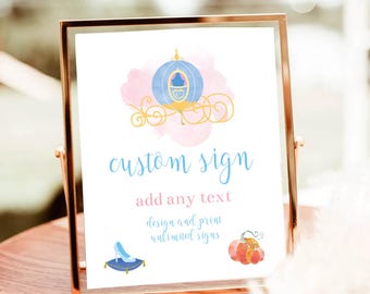 May include: A framed sign with a gold-colored metal frame. The sign features a blue and gold carriage illustration, the words "custom sign" in light blue, and other text. A blue slipper and a pumpkin are also illustrated.