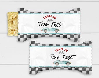 May include: Two personalized candy bar wrappers with a checkered pattern and a blue race car. The text on the wrappers reads "Liam is Two Fast".