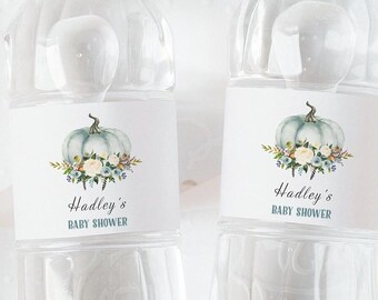 May include: Two water bottle labels with a watercolor illustration of a blue pumpkin with white flowers and greenery. The text on the labels reads "Hadley's Baby Shower".