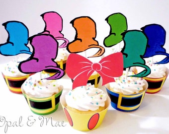 May include: A set of colorful cupcake toppers featuring whimsical hats with a red bow. The toppers are perfect for a birthday party or special occasion.