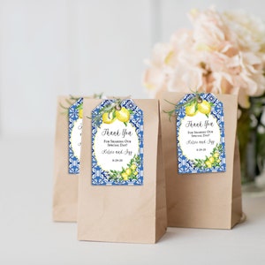 May include: Brown paper gift bags with decorative tags. The tags feature a blue and white tile design, lemons, and the text "Thank You For Sharing Our Special Day!" with names and a date.