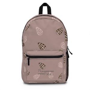 May include: A dusty rose backpack featuring a repeating pattern of dark brown and light beige shell-like shapes. The front pocket displays the text Papa Pikake in a cursive font. The bag includes a black top handle, black zippers, and a side mesh pocket.