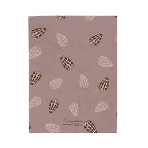 May include: A rectangular fabric item in a dusty mauve shade featuring a repeating pattern of teardrop-shaped shell motifs in dark brown and light pink. The text Papa Pikake is printed in a small, dark script near the bottom centre edge.
