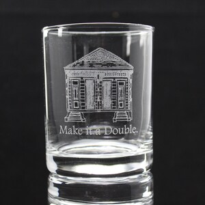 May include: A clear glass shot glass with an etched design of a house with the text "Make it a Double."