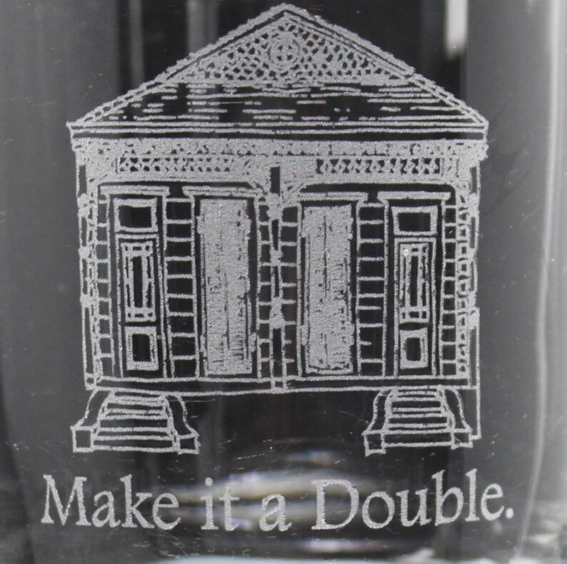 May include: Etched glass with a black and white image of a New Orleans style house. The text "Make it a Double." is below the image.