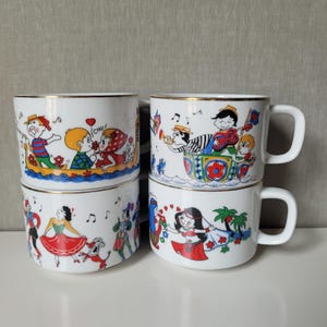 Può includere: Quattro tazze in ceramica bianca con bordi dorati, ognuna caratterizzata da colorate illustrazioni a cartoni animati di persone in varie scene, tra cui una coppia in barca, musicisti, ballerini e una persona con gonna rossa vicino alle palme.