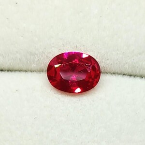 Peut inclure: Une pierre précieuse rubis de forme ovale. La gemme est d'un rouge profond et saturé, avec des facettes qui captent la lumière. Le rubis est posé sur un fond blanc doux, soulignant son éclat. Idéal pour la joaillerie.