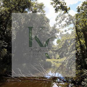 Puede incluir: Fotografía de paisaje de un río rodeado de árboles verdes bajo un cielo parcialmente nublado. La imagen incluye un logotipo con el texto "Kaylie Owen Photography".