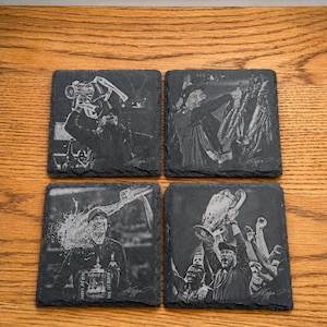 May include: Four square black slate coasters featuring laser-engraved images of a soccer manager celebrating with various trophies. Each coaster displays a distinct scene of victory, including a person holding a cup and a signature at the bottom.