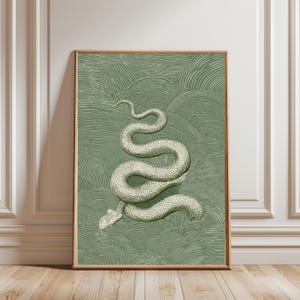 Może przedstawiać: Oprawiony wydruk artystyczny przedstawiający szczegółową ilustrację węża w odcieniach bieli i szarości. Wąż umieszczony jest na zielonym, teksturowanym tle z falistym wzorem. Grafika prezentowana jest w drewnianej ramie.