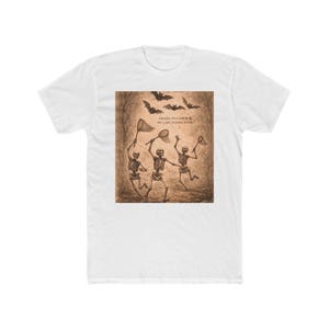 May include: White t-shirt featuring a sepia-toned graphic of three skeletons attempting to catch bats with nets. The image includes the text "TRYING TO CATCH MY LAST FLYING FUCK."