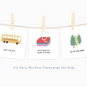 Puede incluir: Tres tarjetas ilustradas con las frases "Ride the Bus", "Fold and Put Away Clothes" y "Go to the Park". Las tarjetas están suspendidas por pinzas en una cuerda. El texto "142 Daily Routine Flashcards for Kids" está debajo.