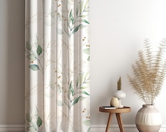 May include: A white curtain with a botanical design featuring green leaves and gold-colored outlines. The curtain is hanging in front of a white wall. The design includes small gold accents.