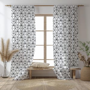 May include: White window curtains with a geometric black triangle pattern. The curtains hang on a wooden rod in front of a window. The room has a wooden bench, a round rug, and decorative plants.