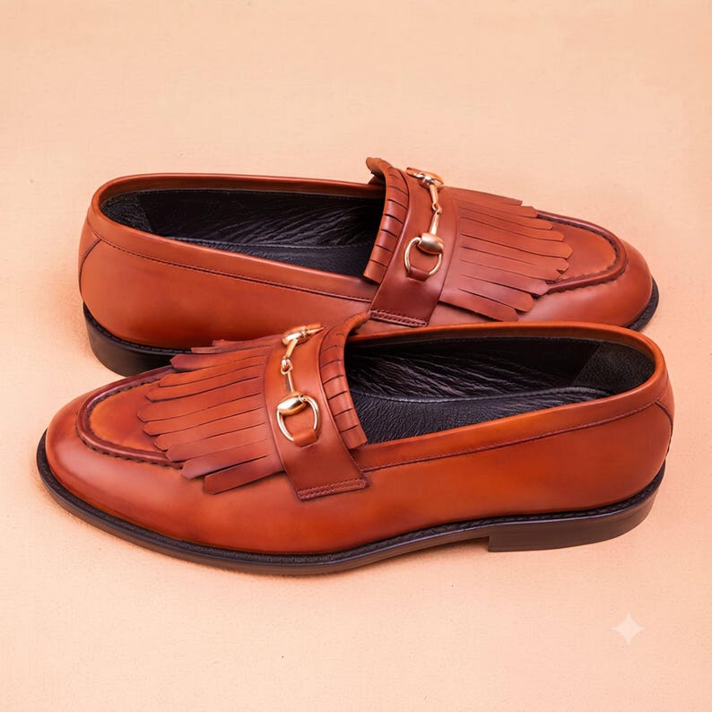 Handmade brown leather fringe loafers for men with metal bit detail, premium slip-on formal dress shoes crafted from genuine leather for weddings and business wear.