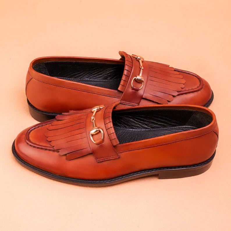 Handmade brown leather fringe loafers for men with metal bit detail, premium slip-on formal dress shoes crafted from genuine leather for weddings and business wear.