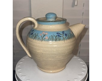 Flores en una tetera de cerámica vintage pintada a mano