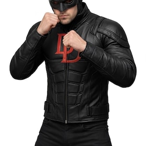May include: Black leather jacket with a red "D" logo on the chest. The jacket has a quilted design and a zipper closure. The person is wearing a black mask with horns and black pants. The person is in a fighting stance.