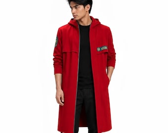 May include: A long-length red hooded coat featuring a full-length front zipper, long sleeves, and two rectangular patches on the chest and sleeve. The chest patch displays the text "SEED" in yellow lettering alongside a circular yellow emblem.