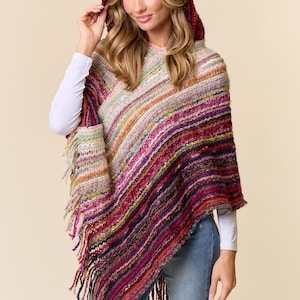 May include: A hooded poncho with a colorful striped design. The poncho features a mix of red, purple, orange, and cream colors. It has a fringed hem and is made of a thick, woven material.